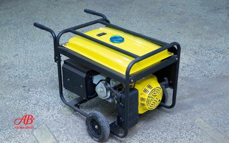 AB Electrical Services Portable yellow generator on wheels with a black frame on a concrete floor. Orange County CA