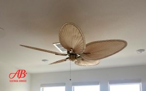 AB Electrical Services Ceiling fan with five leaf-shaped blades and a pull chain, installed on a white ceiling with recessed lighting and visible vents. Orange County CA